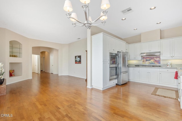 kitchen featuring stainless steel appliances, open floor plan, light countertops, and white cabinets