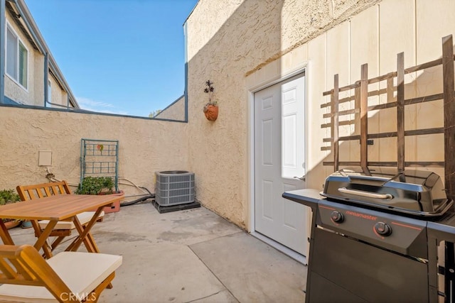 view of patio / terrace with central AC, outdoor dining area, a grill, and fence