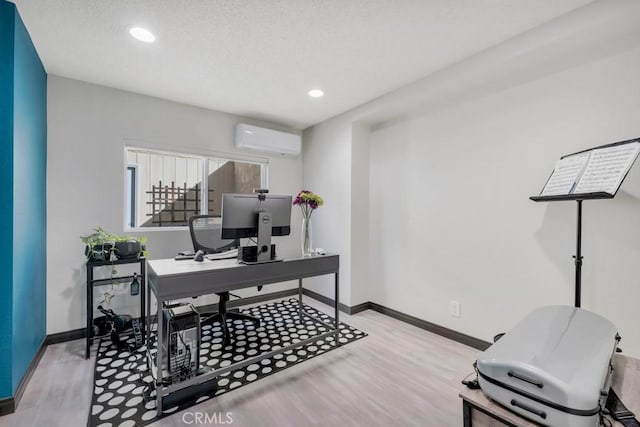 home office featuring an AC wall unit, light wood finished floors, and baseboards