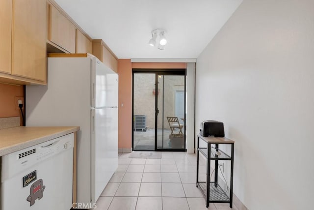 kitchen with light tile patterned floors, light countertops, white dishwasher, and light brown cabinets