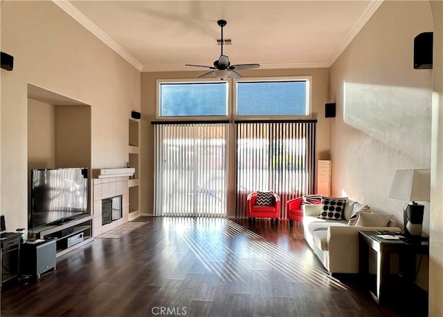 living area featuring dark wood-style floors, plenty of natural light, ceiling fan, and ornamental molding