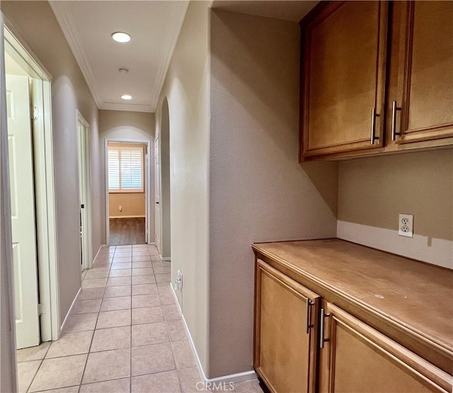 hall with light tile patterned floors, ornamental molding, recessed lighting, and baseboards