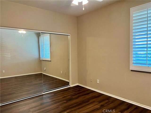 30659 Lajoe St, Menifee, CA 92584 - unfurnished bedroom featuring wood finished floors, baseboards, a ceiling fan, a closet, and multiple windows
