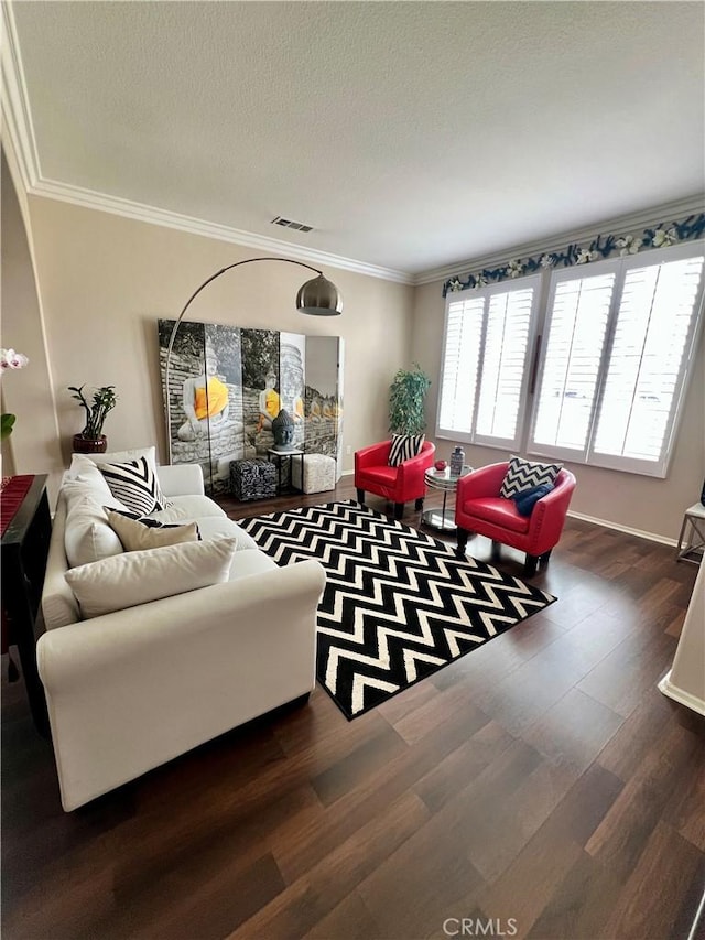 living area featuring dark wood-type flooring, visible vents, crown molding, and a textured ceiling