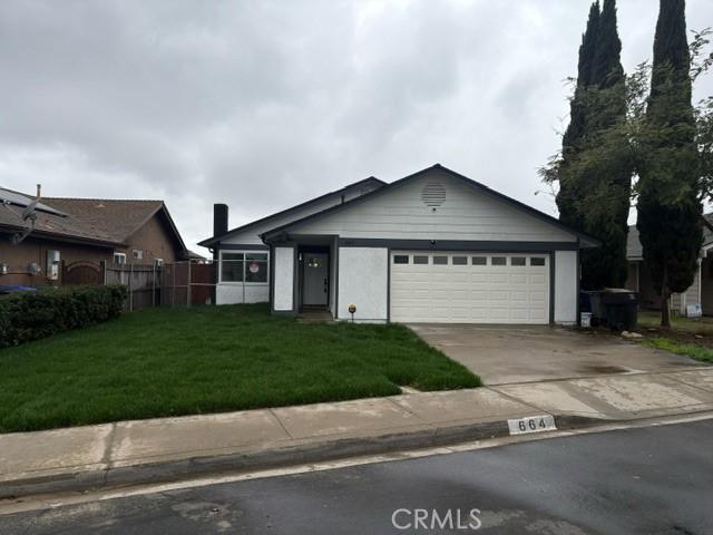 view of front of home with a garage, fence, concrete driveway, and a front yard