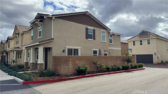 view of side of property with fence, a residential view, and stucco siding