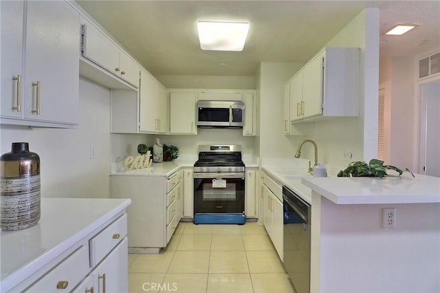 kitchen with appliances with stainless steel finishes, light countertops, a sink, and light tile patterned flooring