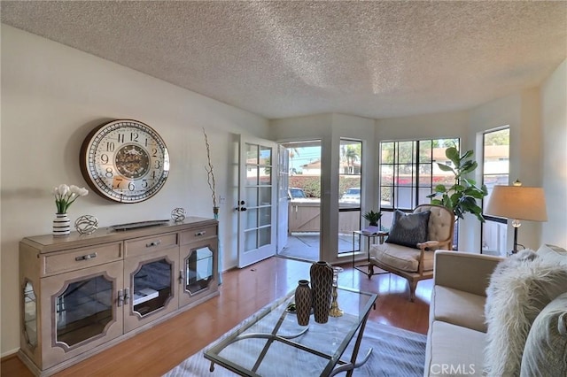 living area with a textured ceiling and wood finished floors