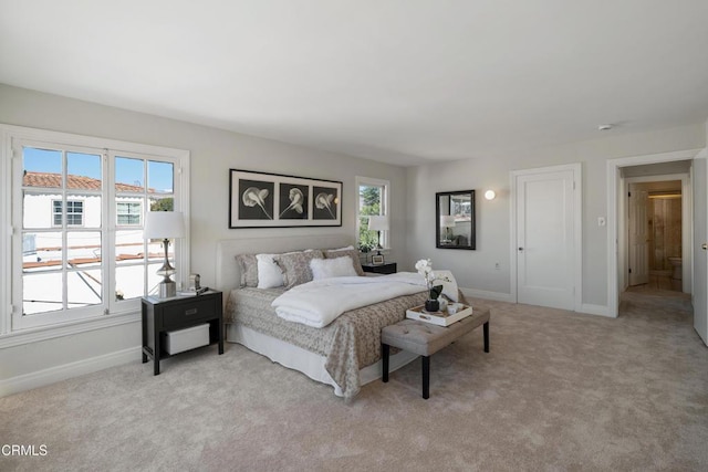 bedroom featuring light carpet and baseboards