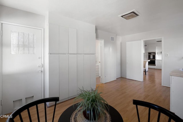 foyer featuring light wood-type flooring and visible vents