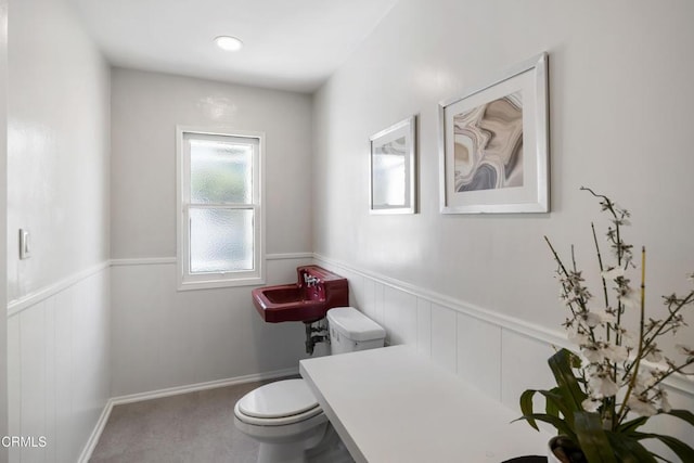 bathroom with wainscoting and toilet