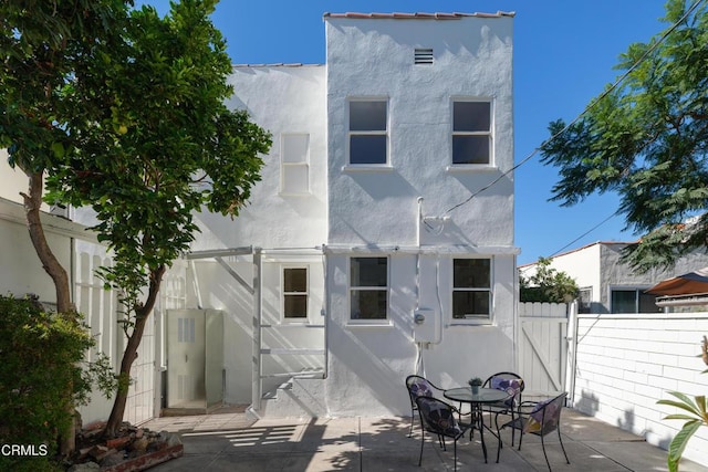 back of house featuring fence, a patio, and stucco siding