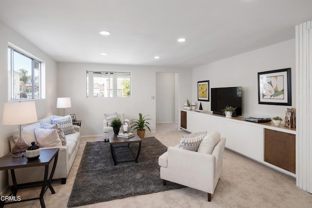 living room featuring recessed lighting, light colored carpet, and plenty of natural light