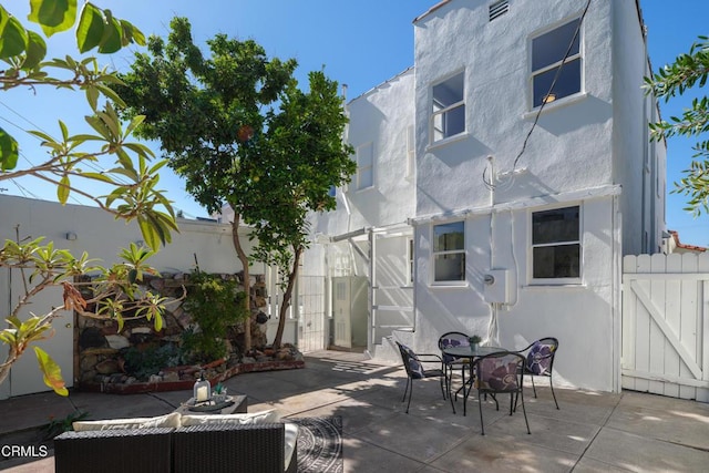 view of patio / terrace with a gate, fence, and outdoor dining space