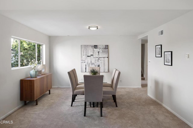 dining room featuring light carpet, baseboards, and visible vents