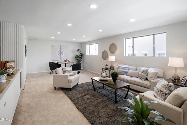 living room featuring baseboards, recessed lighting, and light colored carpet