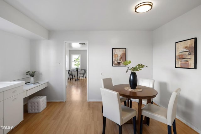 dining room with light wood-style floors and baseboards