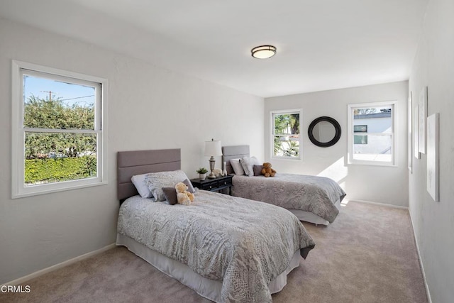 bedroom with light carpet and baseboards