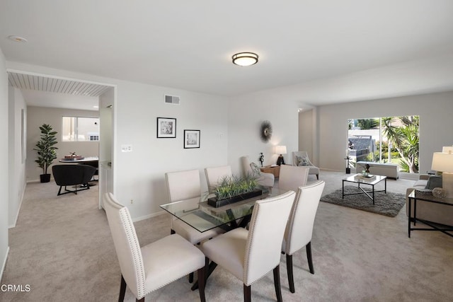 dining room with visible vents, light carpet, and baseboards