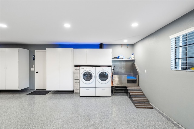 laundry room featuring recessed lighting, cabinet space, and washing machine and clothes dryer