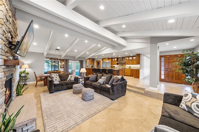 living area with vaulted ceiling with beams, a fireplace, baseboards, and light tile patterned floors