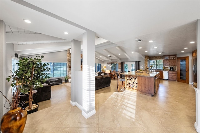 kitchen with open floor plan, appliances with stainless steel finishes, lofted ceiling with beams, and visible vents