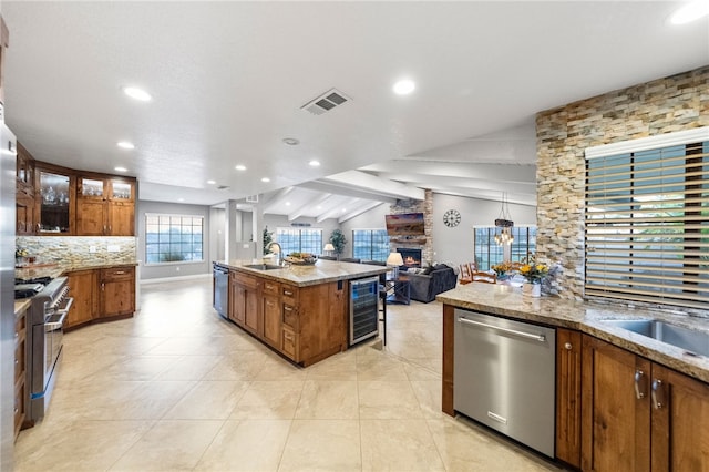 kitchen with beverage cooler, visible vents, lofted ceiling with beams, a sink, and stainless steel appliances