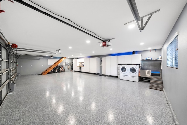 garage with a garage door opener, independent washer and dryer, and baseboards