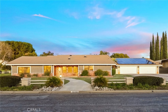 single story home featuring a garage and a lawn