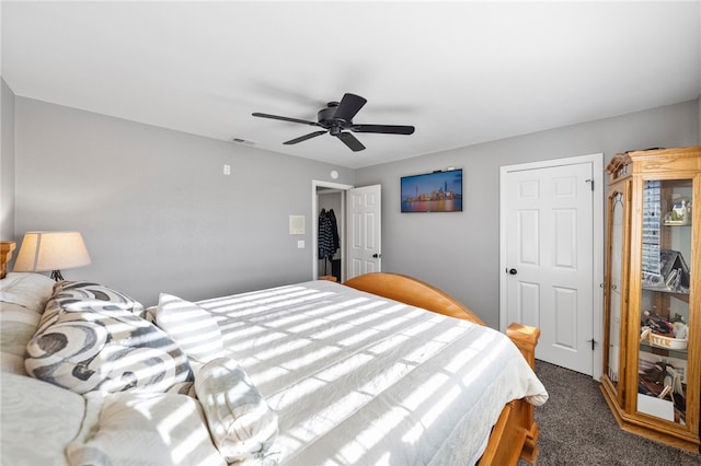 bedroom with visible vents, dark carpet, and ceiling fan