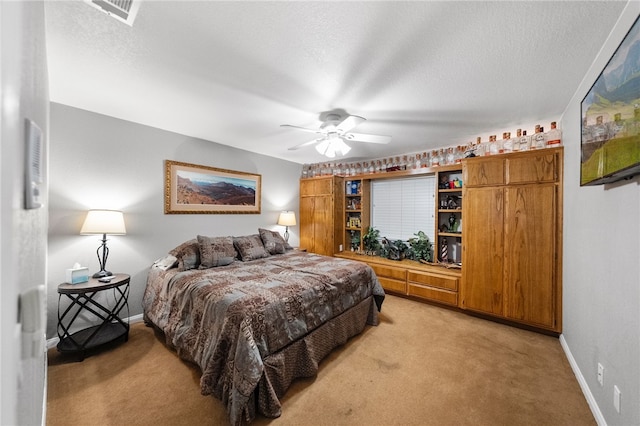 bedroom with visible vents, light colored carpet, a textured ceiling, and baseboards