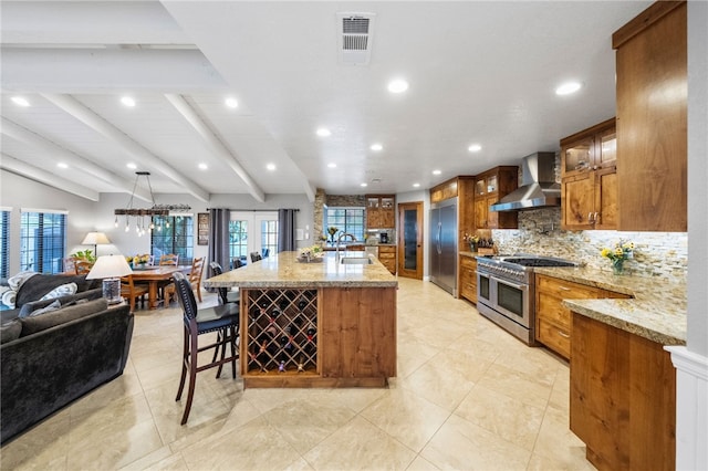 26280 Thacker Dr, Hemet, CA 92544 - kitchen with brown cabinets, decorative backsplash, visible vents, wall chimney exhaust hood, and high quality appliances