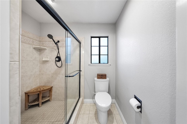 bathroom with tile patterned floors, a stall shower, toilet, and baseboards