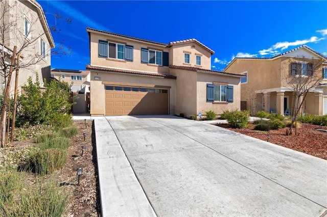 mediterranean / spanish-style home with driveway, a tiled roof, an attached garage, and stucco siding