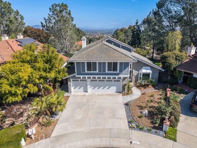 view of front of house with a garage, driveway, and a chimney