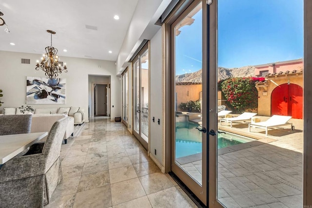 doorway to outside with visible vents, an inviting chandelier, a mountain view, and recessed lighting