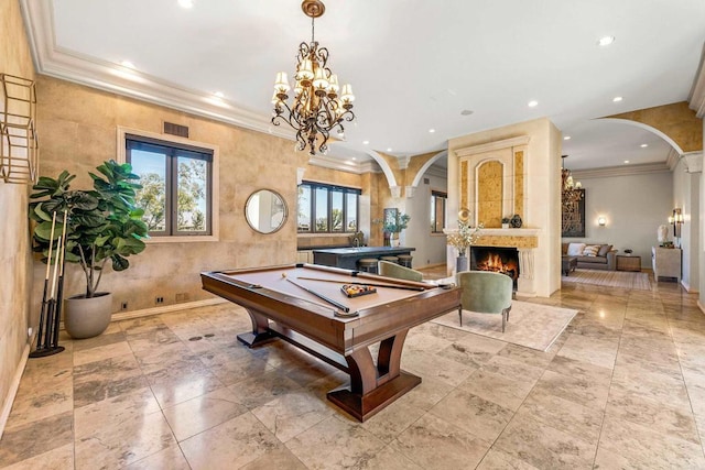 rec room featuring arched walkways, ornamental molding, a fireplace, and visible vents