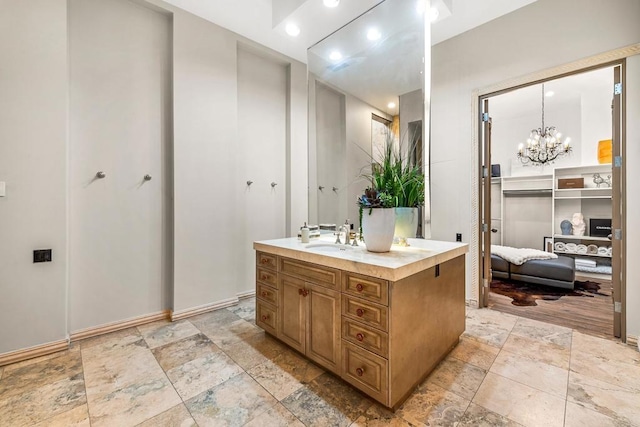 bathroom featuring stone finish floor, vanity, and an inviting chandelier