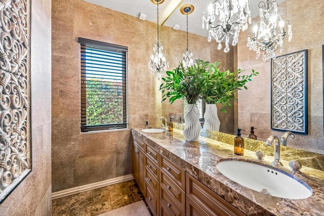 full bath with double vanity, an inviting chandelier, and a sink