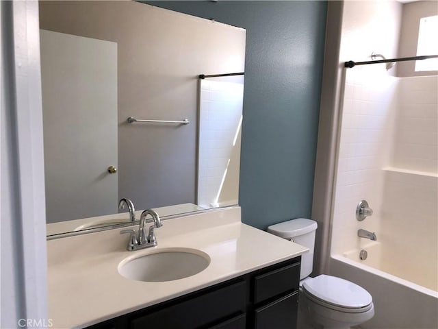 bathroom featuring washtub / shower combination, vanity, and toilet