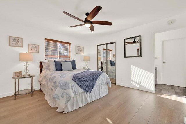 bedroom featuring a ceiling fan, a closet, baseboards, and light wood finished floors