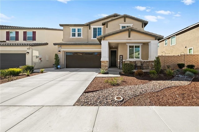 view of front of house featuring a garage, concrete driveway, stone siding, and stucco siding