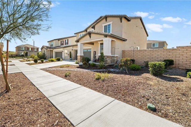 view of front facade featuring a residential view, fence, a tiled roof, and stucco siding