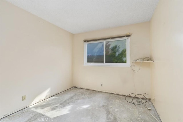 unfurnished room with concrete flooring