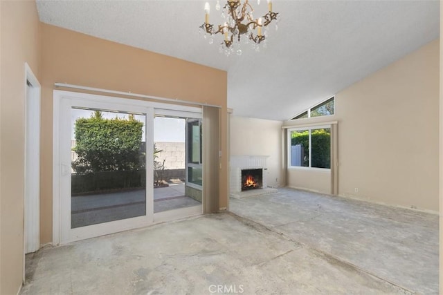 unfurnished living room with vaulted ceiling, a brick fireplace, concrete flooring, and a healthy amount of sunlight