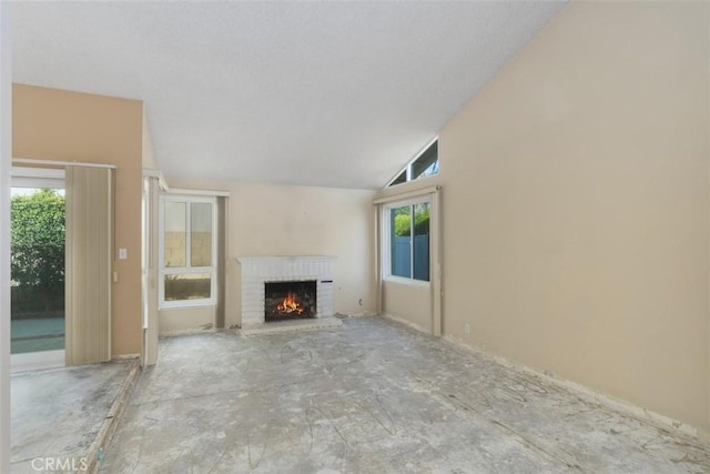 unfurnished living room featuring high vaulted ceiling and a brick fireplace