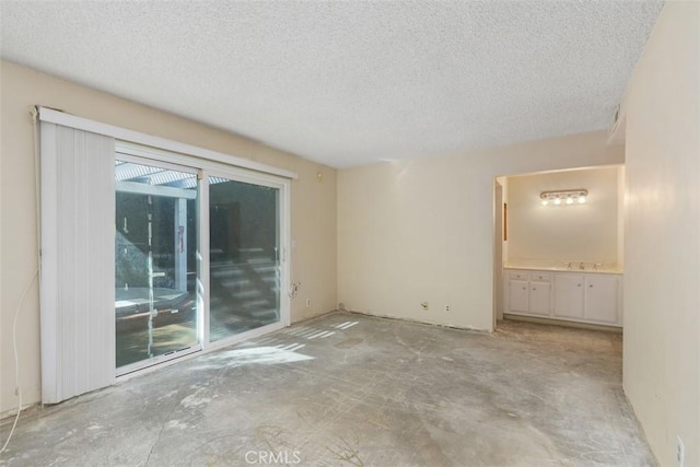 unfurnished room featuring unfinished concrete floors and a textured ceiling