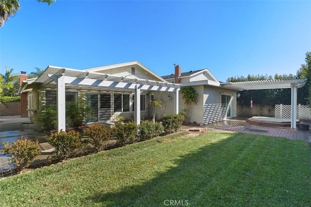 back of house featuring stucco siding, a lawn, a chimney, and a pergola