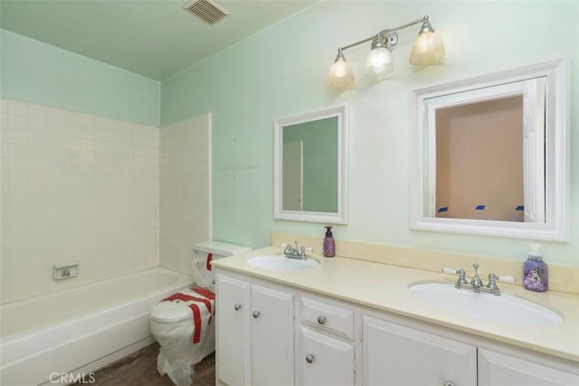 bathroom with double vanity, washtub / shower combination, visible vents, and a sink