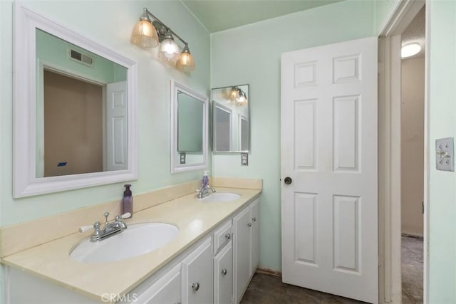 bathroom with visible vents, a sink, and double vanity